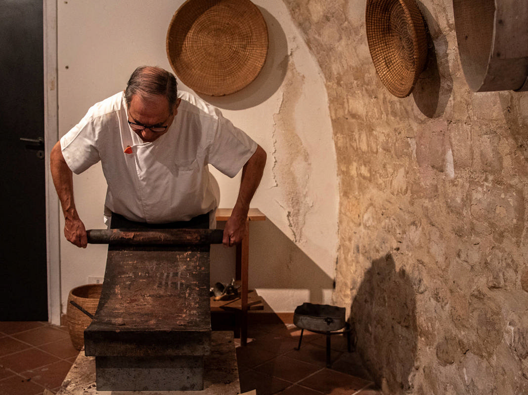 Un maestro cioccolatiere al lavoro sul metate